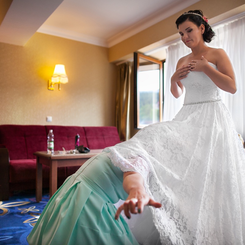 Panna młoda zakładająca białą suknię ślubną w hotelu w Karpaczu