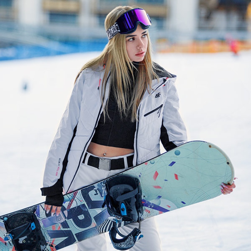 piękna blondynka w goglac trzyma deskę snowboardową